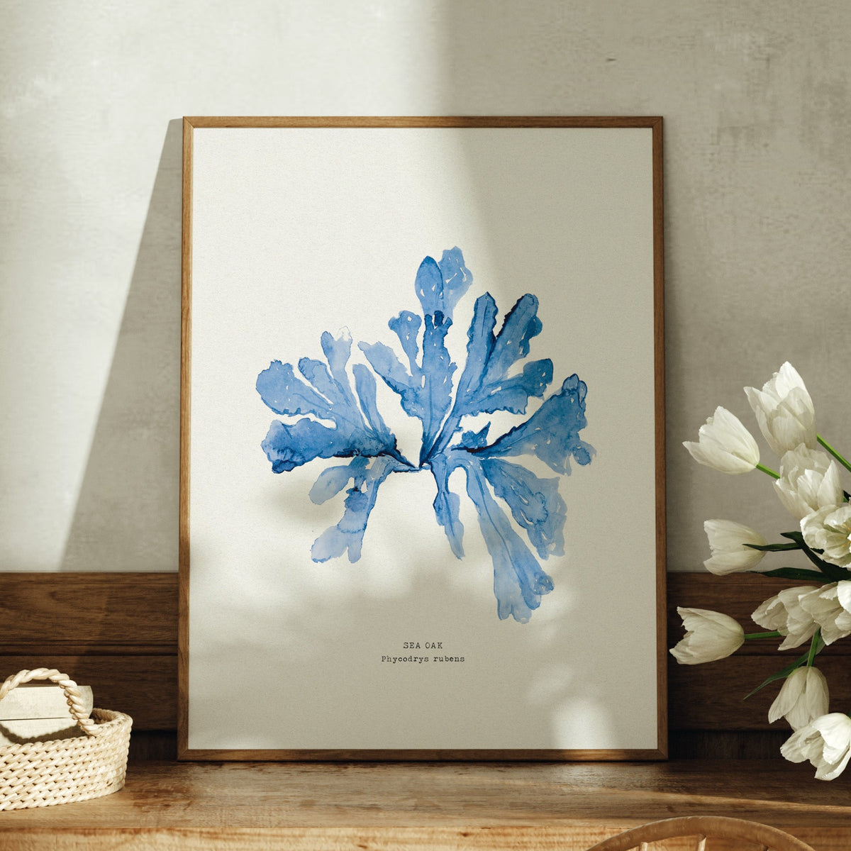 sea oak watercolour painting in blue - painting of seaweed framed in natural wood frame on sideboard