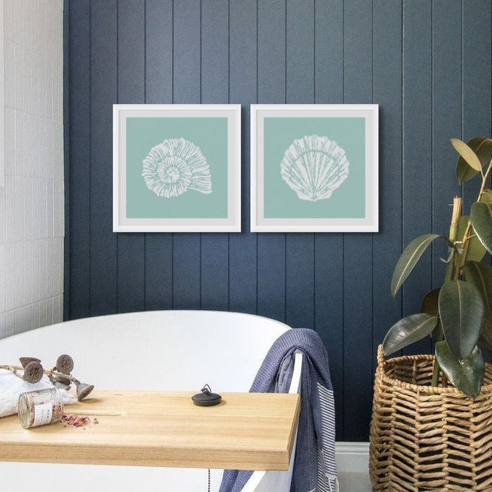 Set of two shell prints in bathroom above freestanding bath