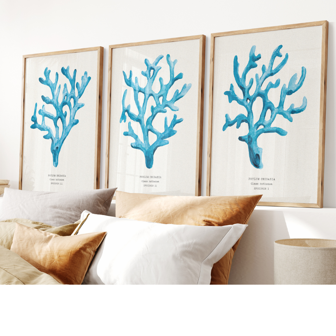 Set of three coral art prints - coral paintings as a set framed in natural frame above a bed. 