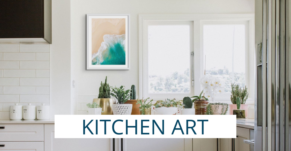 modern kitchen with white shaker cabinets and some worktop. White painted kitchen wall with aerial beach framed photo on the wall