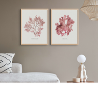 set of two red seaweed prints above a bed with boho lights - seaweed art prints