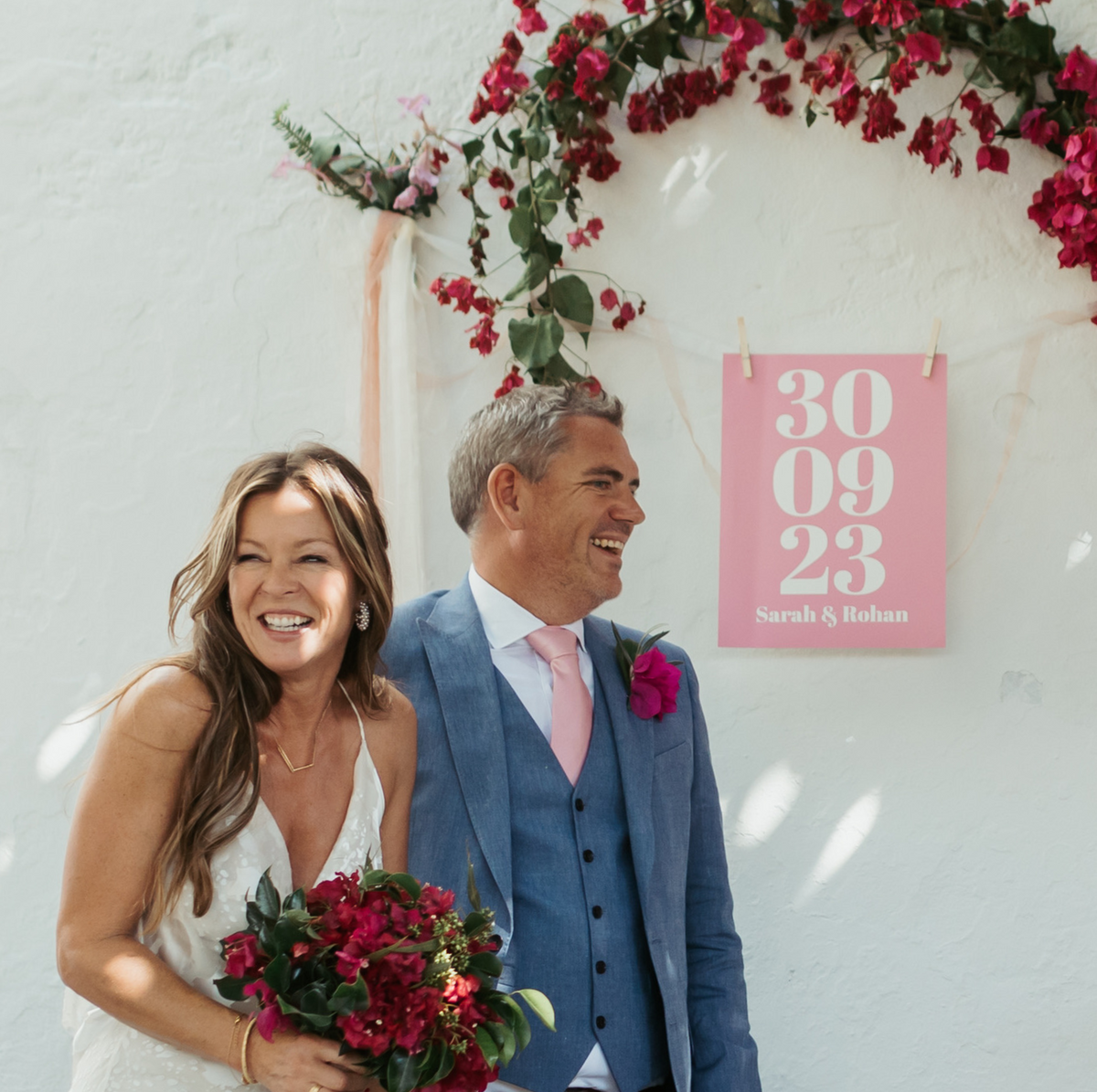 couple getitng married in front of a custom wedding art print with the date of their wedding and their names printed 