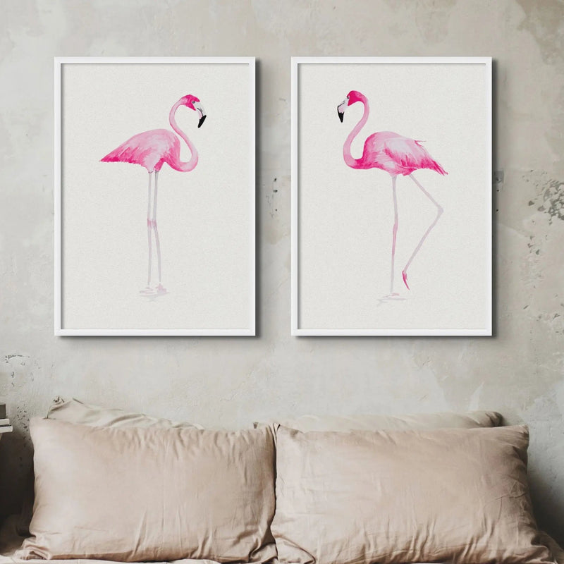 set of two framed flamingo wall art prints above a bed