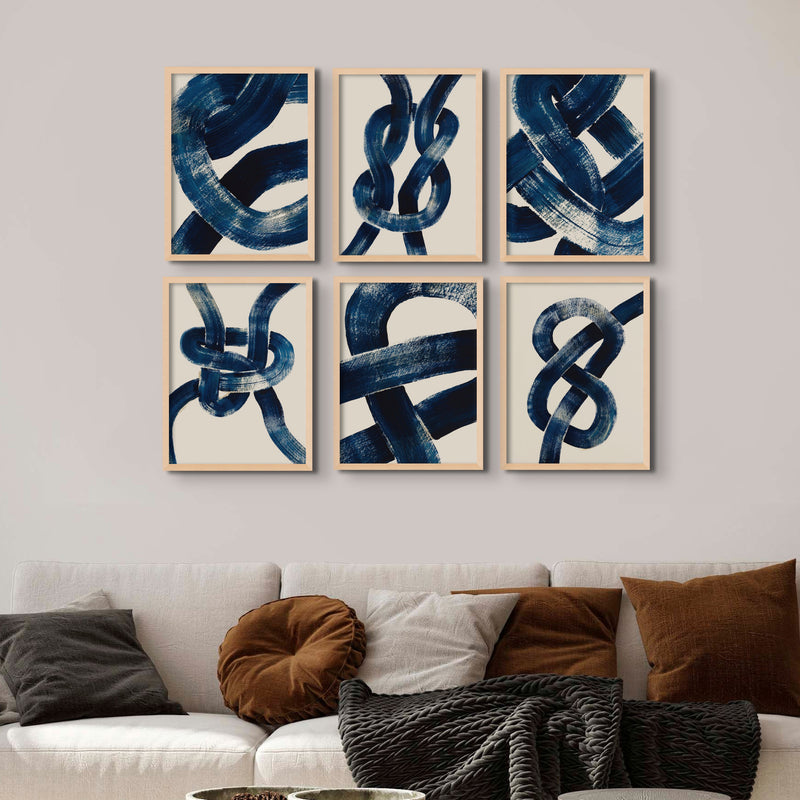 a set of six framed prints of knots above a brown sofa