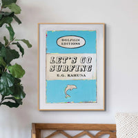 framed blue book cover print with let's go surfing in type on the front. Surf themed art print