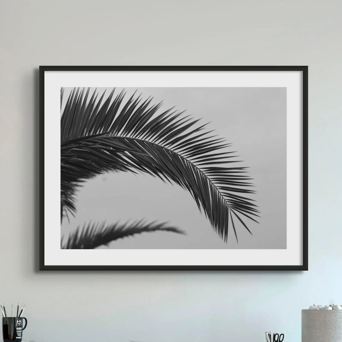 Paml leaf print - black & white beach art photograph of a palm tree frond against a grey sky in a black frame - beach house art