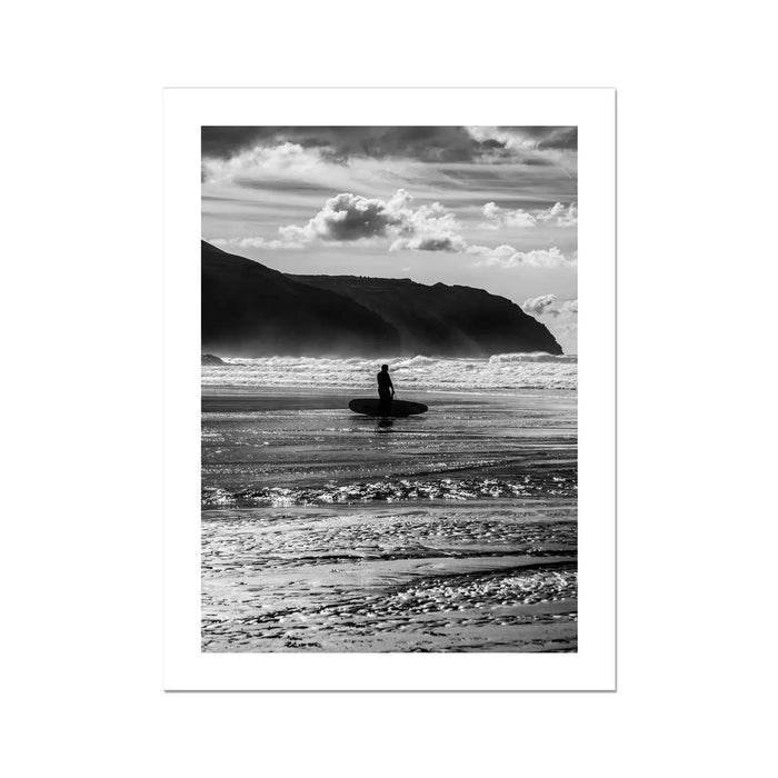 black & white beach art photograph of a solitary surfer walking into the waves - beach house art